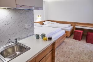 a kitchen with two beds and a sink in a room at Spa & wellness Villa Garetov Konak in Prolomska Banja