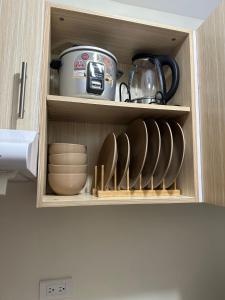 ダバオシティにある2 BR Unit In Seawind Condo [New&FullyFurnished]の食器とティーポットが入った戸棚