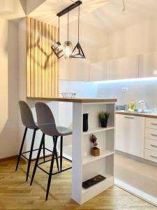 a kitchen with a island with two chairs and a table at Bright Scandi Apartment in Skopje