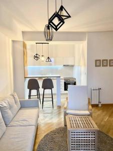 a living room with a couch and a dining room at Bright Scandi Apartment in Skopje