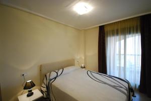 Un dormitorio con una cama grande y una ventana en Apartment De Jardines, en Denia 41 fotos más