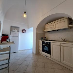 eine Küche mit weißen Schränken und einem Herd mit Backofen in der Unterkunft Historich house Largo Martellotta 44 in Alberobello