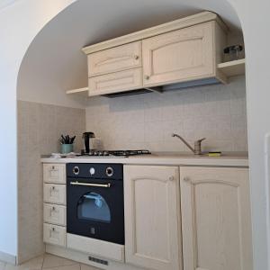 eine Küche mit einem schwarzen Herd und weißen Schränken in der Unterkunft Historich house Largo Martellotta 44 in Alberobello