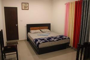 a bedroom with a bed and a red curtain at Cassa Cottage Munnar in Kallar Vattiyar