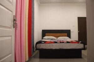 a bedroom with a bed with colorful curtains at Cassa Cottage Munnar in Kallar Vattiyar