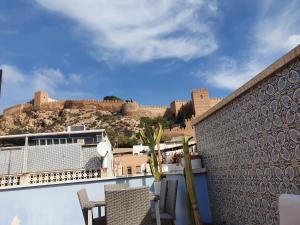 a balcony with chairs and a view of a castle at Casa Azul de la Almedina de Almería in Almería