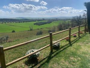 une clôture en bois au-dessus d'un champ vert dans l'établissement Casa Paola nel Chianti, à Castelnuovo Berardenga