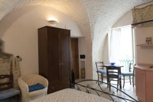 a room with a bed and a table and chairs at Casetta Piazza Emanuele in Cisternino