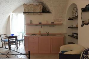 a kitchen with a sink and a table at Casetta Piazza Emanuele in Cisternino +2 photos