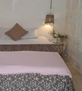 Un dormitorio con 2 camas y una mesa con una planta en Casa Baronessa, en Ceglie Messapica