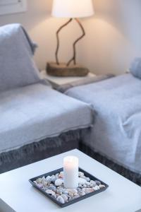 świeca na tacy na stole obok kanapy w obiekcie Matina's apartment w mieście Poros