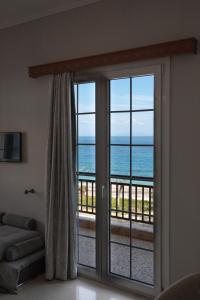 een kamer met een glazen schuifdeur en uitzicht op de oceaan bij Matina's apartment in Póros