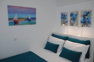 um quarto com uma cama com almofadas azuis e brancas em ALBATROS em Loutraki
