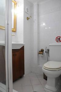 uma casa de banho branca com um WC e um lavatório em ALBATROS em Loutraki