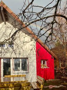 uma casa vermelha e branca com um banco à frente em Chalet cosy avec vue dégagée em Métabief