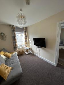 a living room with a couch and a flat screen tv at The Hurstmere in Blackpool