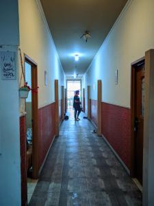 a person walking down a hallway in a building at Pondok Wisata DEPORIZ 2 in Porisgaga