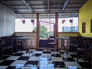 a restaurant with black chairs and tables and windows at Pondok Wisata DEPORIZ 2 in Porisgaga