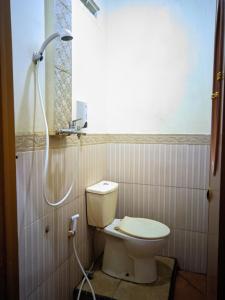 a bathroom with a toilet and a shower at Pondok Wisata DEPORIZ 2 in Porisgaga