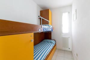 a small bedroom with a bunk bed with a yellow and blue crib at Residence Maricel in Lido di Jesolo +72 photos