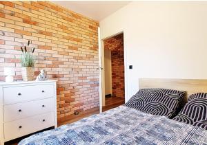 Un dormitorio con una pared de ladrillo y una cama en Apartament Kotwica z prywatnym miejscem w hali garażowej, en Świnoujście