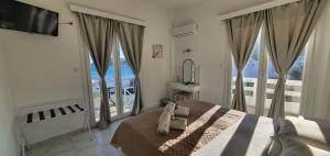 Syros Holidays في Vári: غرفة نوم بسرير ونافذة كبيرة