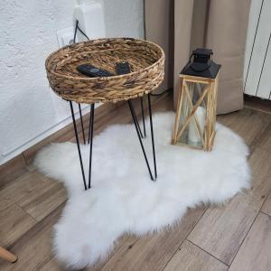 a wicker table and stool on a white fluffy rug at Licul Apartment in Rovinj