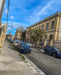 una fila de autos estacionados al lado de una calle en Viale degli Studenti Apartment, en Lecce