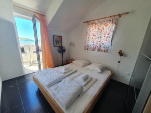 ヴェラ・ルカにあるCasa Naranja Croatiaのベッドと大きな窓のある寝室