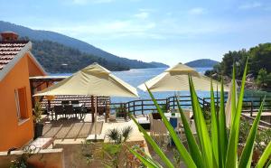 ヴェラ・ルカにあるCasa Naranja Croatiaの水辺のパティオに置かれた2本の白い傘