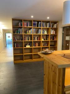 a library with wooden shelves filled with books at Ferienwohnung Familienglück in Sankt Englmar