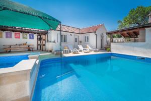 een zwembad voor een huis bij Villa Škrika in Škrip