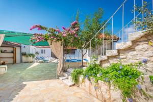 een huis met een tuin met bloemen op een terras bij Villa Škrika in Škrip