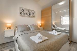 een slaapkamer met een groot bed met handdoeken erop bij Villa Škrika in Škrip +42 foto's