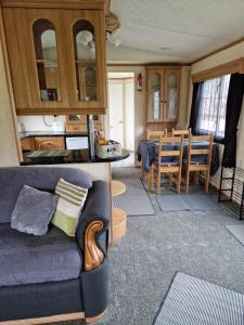 a living room with a couch and a dining room at Static Caravan KL13 in Bettws-Evan