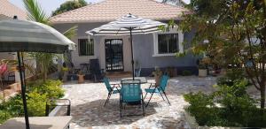 a patio with a table and chairs and an umbrella at The bb's in Brusubi