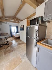 eine Küche mit einem Kühlschrank aus Edelstahl in einem Zimmer in der Unterkunft Adorable Maison Indépendante 30m2 avec Piscine en saison in Cabris