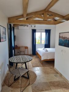 a bedroom with a bed and a table in a room at Adorable Maison Indépendante 30m2 avec Piscine en saison in Cabris +13 photos
