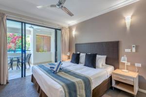 - une chambre avec un grand lit et un balcon dans l'établissement Magnificent 2 bed unit in heart of Port Douglas, à Port Douglas