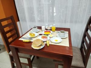 una mesa de madera con desayuno en Dreams House Cusco, en Cusco