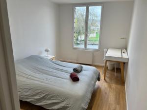 1 dormitorio con cama, escritorio y ventana en Sur le Loing, en Moret-sur-Loing
