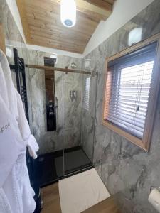 een badkamer met een douche en een glazen deur bij 2 Sinclair bay lodges in Keiss