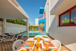 a table with food on a patio with a pool at Villa Acapulco by Algarve Vacation in Albufeira
