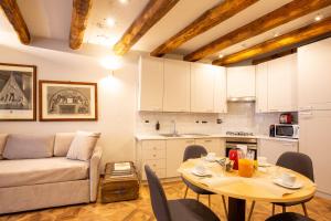 uma cozinha e uma sala de estar com uma mesa e um sofá em Falegnami Boutique Suites - BolognaRooms em Bolonha