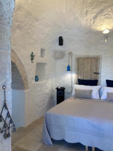 ein Schlafzimmer mit einem Bett in einer weißen Wand in der Unterkunft Lacinera Trulli e Lamie in Ostuni