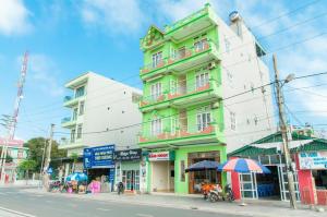 a green and white building on the side of a street at Bảo Ngọc Cô Tô hotel in Dao Co To
