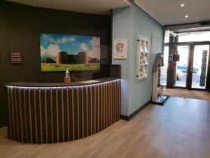 a lobby with a bar with a painting on the wall at Hostal Bríos in Lugo