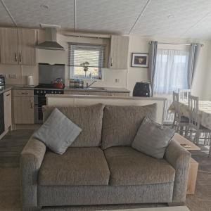 a living room with a couch and a kitchen at Homeston Lodge in Drumlemble