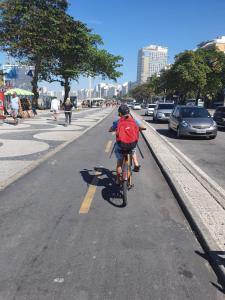 a person riding a bike down a city street at Loft de Luxo no melhor ponto de Copacabana in Rio de Janeiro