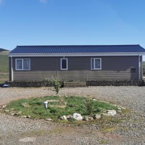 a house with a gravel yard in front of it at Homeston Lodge in Drumlemble